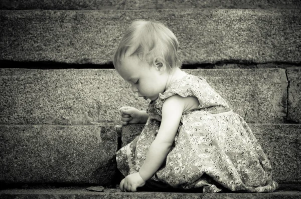 Niedliches kleines Baby findet etwas auf dem Boden — Stockfoto