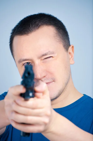 Młody człowiek trzyma pistolet — Zdjęcie stockowe