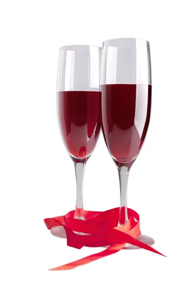 Dit zijn bril met rode wijn en rood lint geïsoleerd — Stockfoto