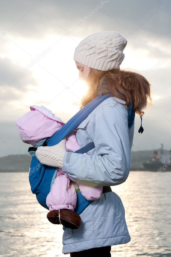 Lifestyle portrait of young mother and baby