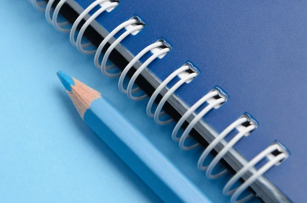 Синий карандаш и спираль блокнота — стоковое фото