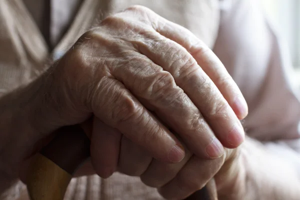 Hand of a senior man with a cane — Stock Photo, Image