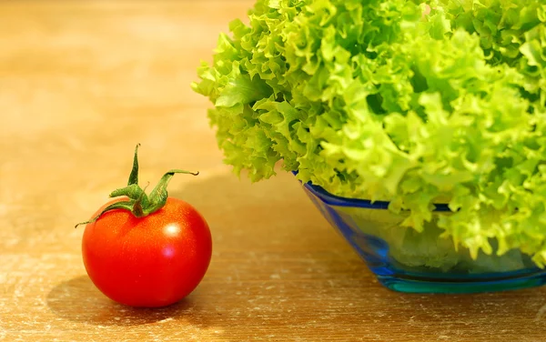 Frischer Salat und eine Tomate — Stockfoto
