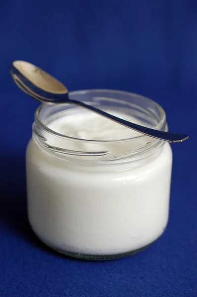 Yoghurt op blauwe achtergrond — Stockfoto