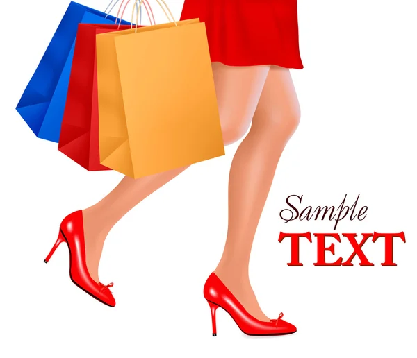 Vista de la cintura hacia abajo de la mujer de compras que usa zapatos rojos de tacón alto y lleva — Vector de stock