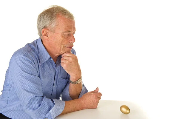 Старший мужчина с золотым яйцом — стоковое фото