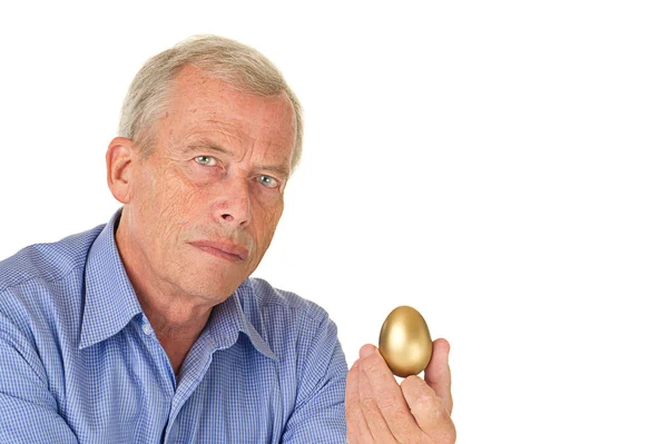 Старший мужчина с золотым яйцом — стоковое фото