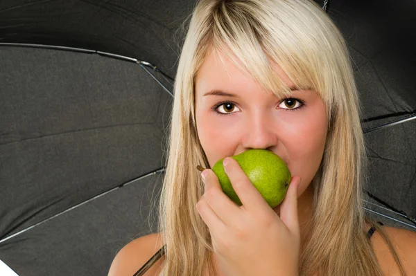 Ung flicka äta ett päron — Stockfoto