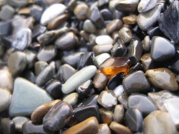 stock image Orange glass laying on the sea shore