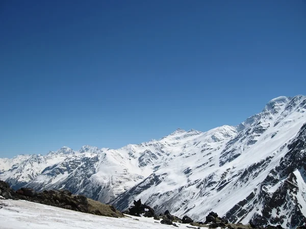 Kaukasus onder de sneeuw en het heldere hemel — Stockfoto