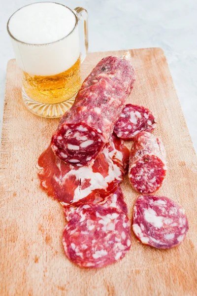 Italian salami and glass of beer outdoor — Stock Photo, Image