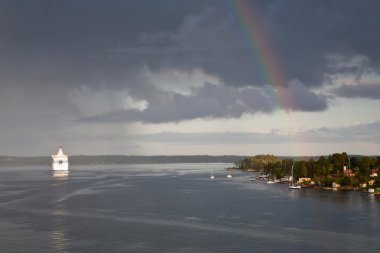 White cruise liner and rainbow