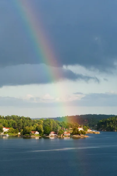 Rainbow under small village on Baltic seashore — Stok fotoğraf