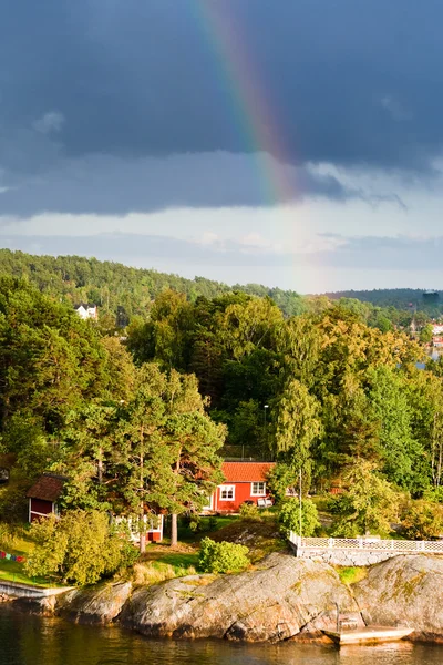 Rainbow under small village — Stok fotoğraf