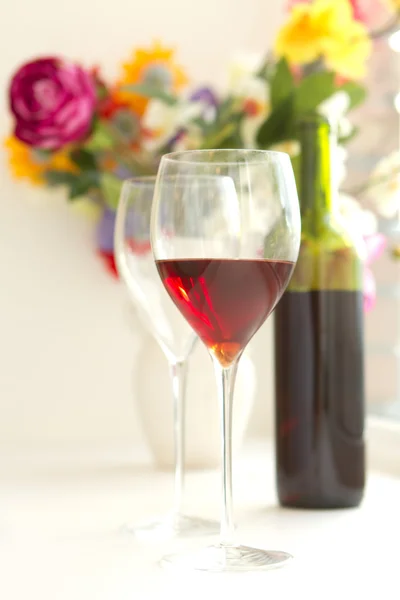对酒眼镜装满红葡萄酒和葡萄酒瓶在 backgrou — 图库照片