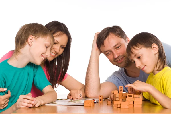 Šťastná rodina hraje u stolu — Stock fotografie
