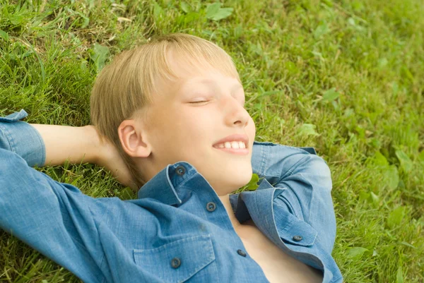 Pojken ligga på gräs — Stockfoto
