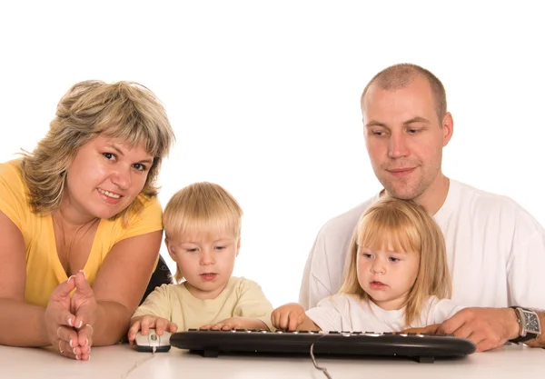 Family at table with computer — Stock Photo, Image