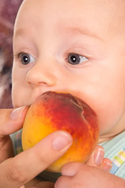 Barnet med en persika — Stockfoto