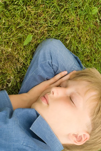 Chłopiec śpi w trawie — Zdjęcie stockowe