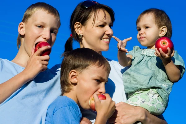 Мама с детьми и яблоками — стоковое фото