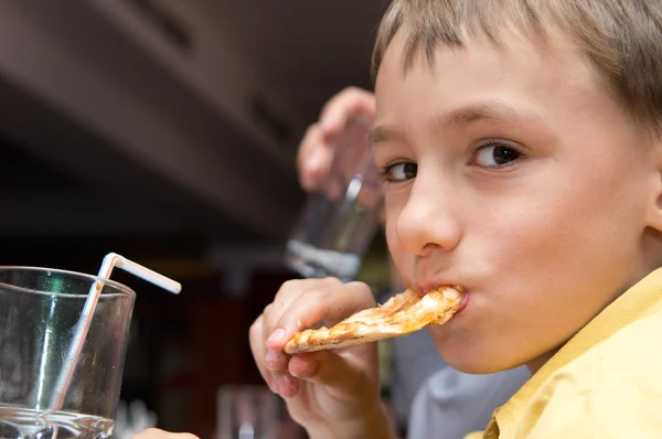 Mladý chlapec s pizzou — Stock fotografie