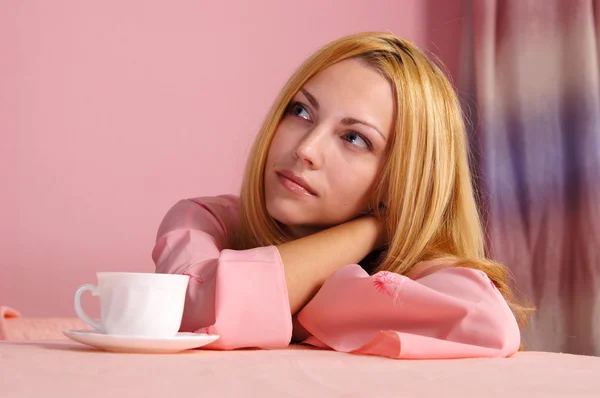 Meisje in roze aan tafel — Stockfoto