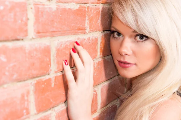 Blonde bij muur — Stockfoto