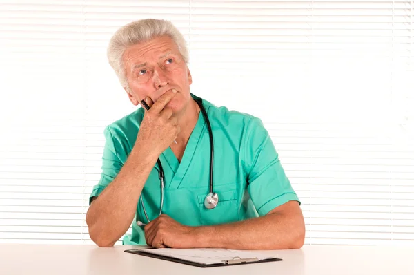 Osoby w podeszłym wieku lekarz przy stole — Zdjęcie stockowe