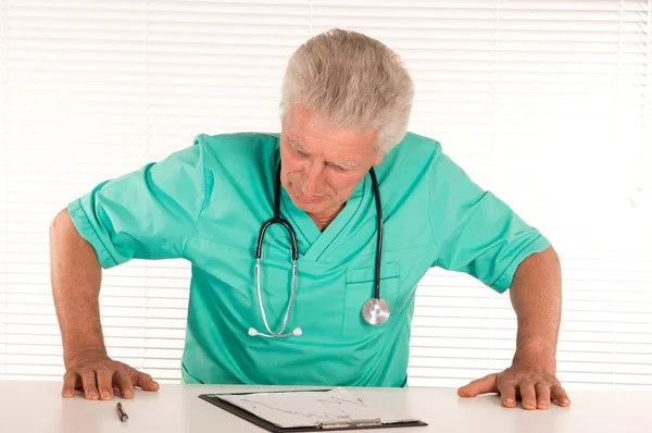 Medico anziano a tavola — Foto Stock