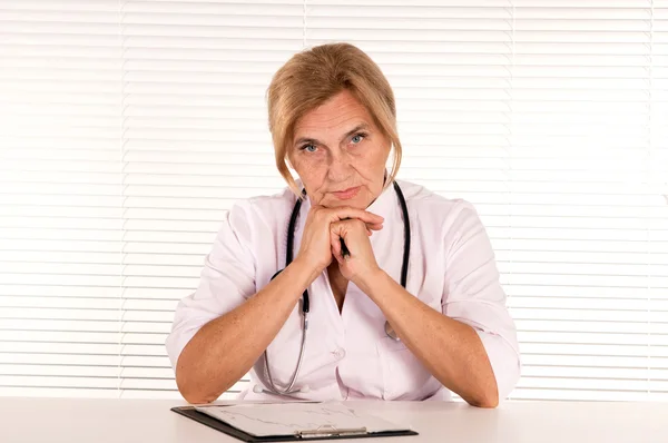 Doctor sits at table — Stock Photo, Image