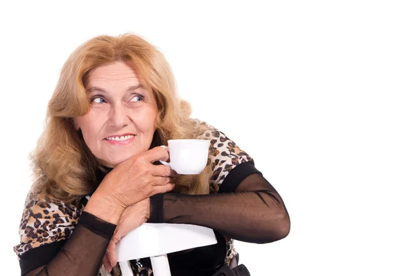 Vecchia donna con tazza sulla sedia — Foto Stock