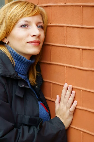 Жінка біля стіни — стокове фото