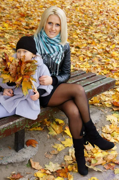 Liten flicka och mamma med blad — Stockfoto