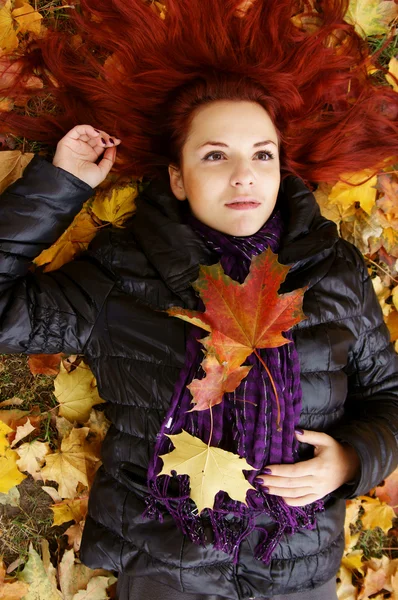 Aranyos lány feküdt a levelek — Stock Fotó