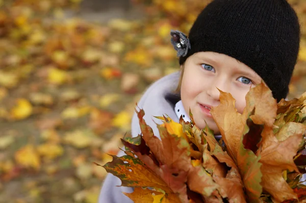 Маленькая девочка с листьями — стоковое фото