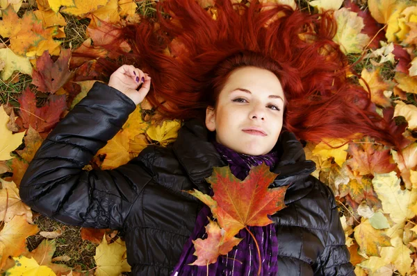 Linda chica acostada en hojas — Foto de Stock