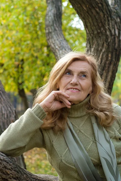 Old woman at tree — Stock Photo, Image