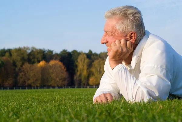 Yaşlı adam çim üzerinde yalan — Stok fotoğraf