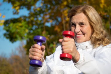 Elderly woman with dumb bells clipart