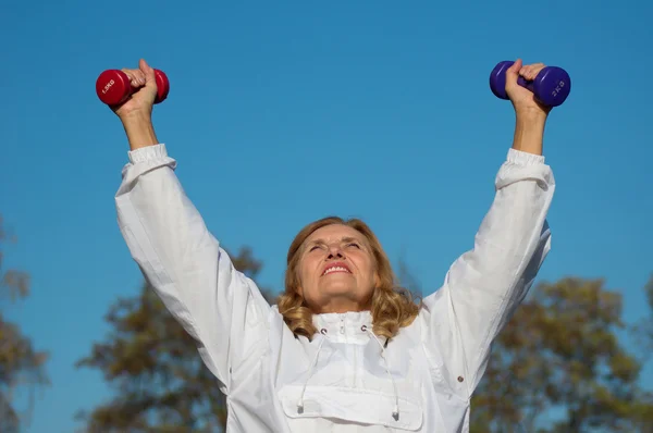 Old woman with dumb bells — Stock Photo, Image