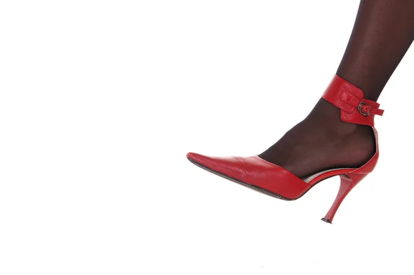 Kvinnliga foten vid röda sko — Stockfoto