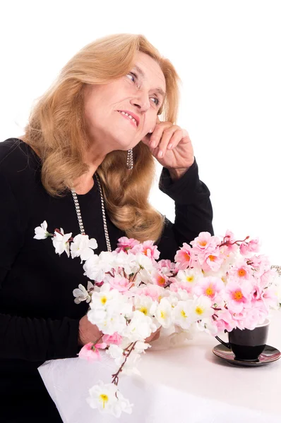 Old woman with flowers — Stock Photo, Image