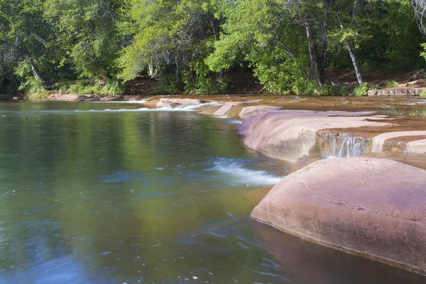 Stream Flowing over Red Rocks