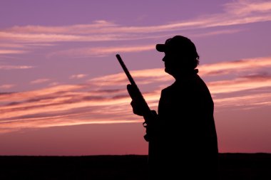 gün batımında av tüfeğiyle Upland avcı
