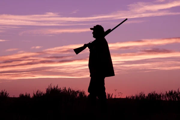Охотник с дробовиком на закате — стоковое фото