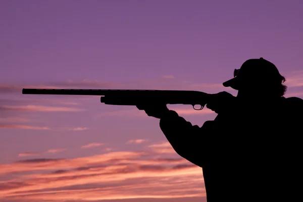 Охотник с ружьем на закате — стоковое фото