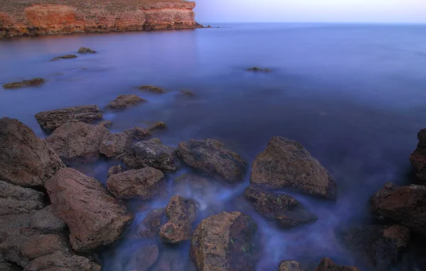 Pedras do mar no litoral com água azul — Fotografia de Stock