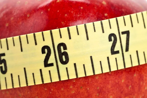 Красное яблоко и рулетка — стоковое фото