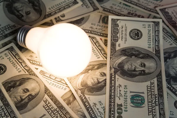 Яркая лампочка и доллар — стоковое фото
